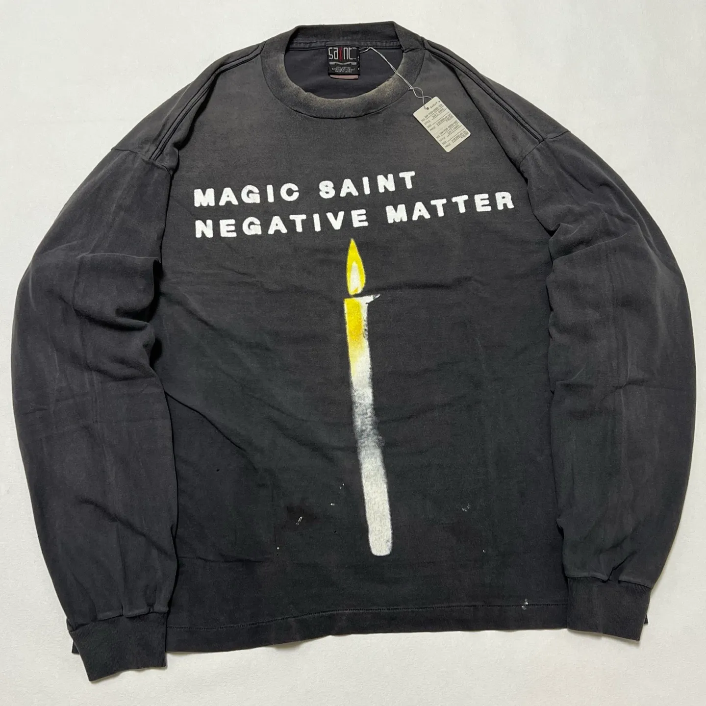 SAINT Mxxxxxx CANDLE LS TEE/BLK Slogan candle distressed long-sleeved TEE with angel short sleeves on the back. Washed black S-XL. Same as the original. Cylindrical side seam OE yarn fabric. Garment dyeing. Faded by heavy washing. Faded by plaster on bust. Correct alignment. Original consistent main mark/wash mark/cherub anti-counterfeiting mark. Original level printing restoration.